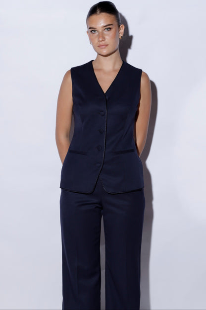 Person wearing a navy vest and pants on a white background 100% wool