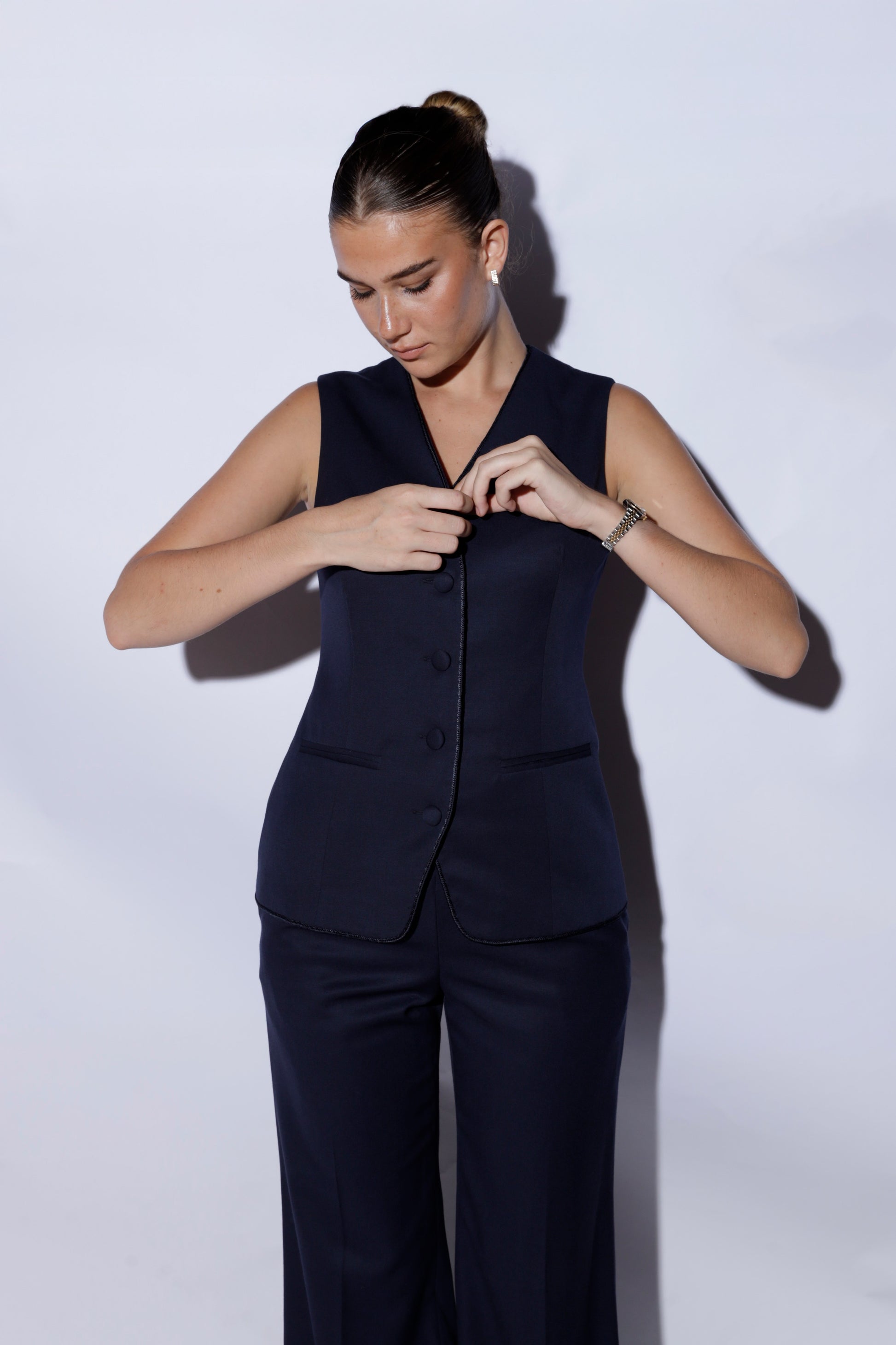Woman wearing a navy blue suit against a white background 100% wool