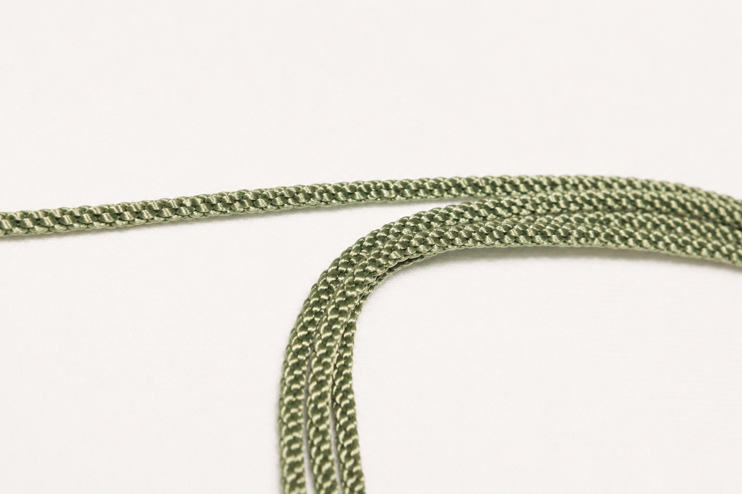 Close-up of green braided rope on a white background