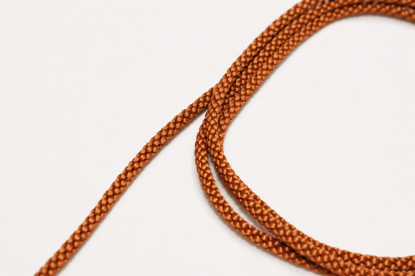 Close-up of brown braided cord on a white background