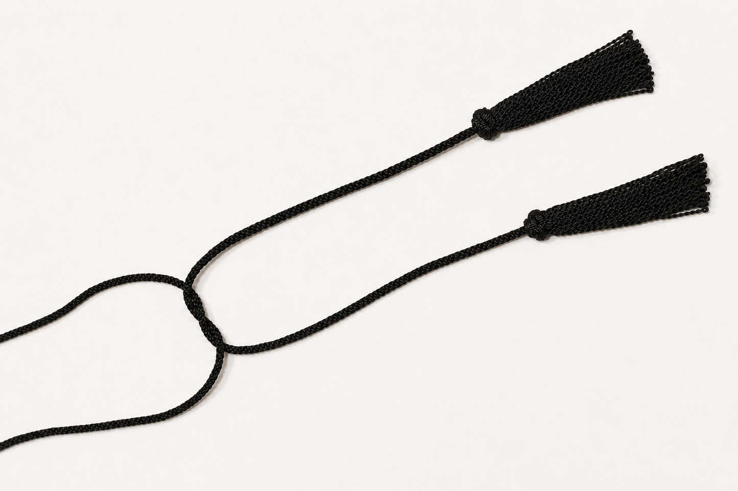 Black cord with two tassels on a white background