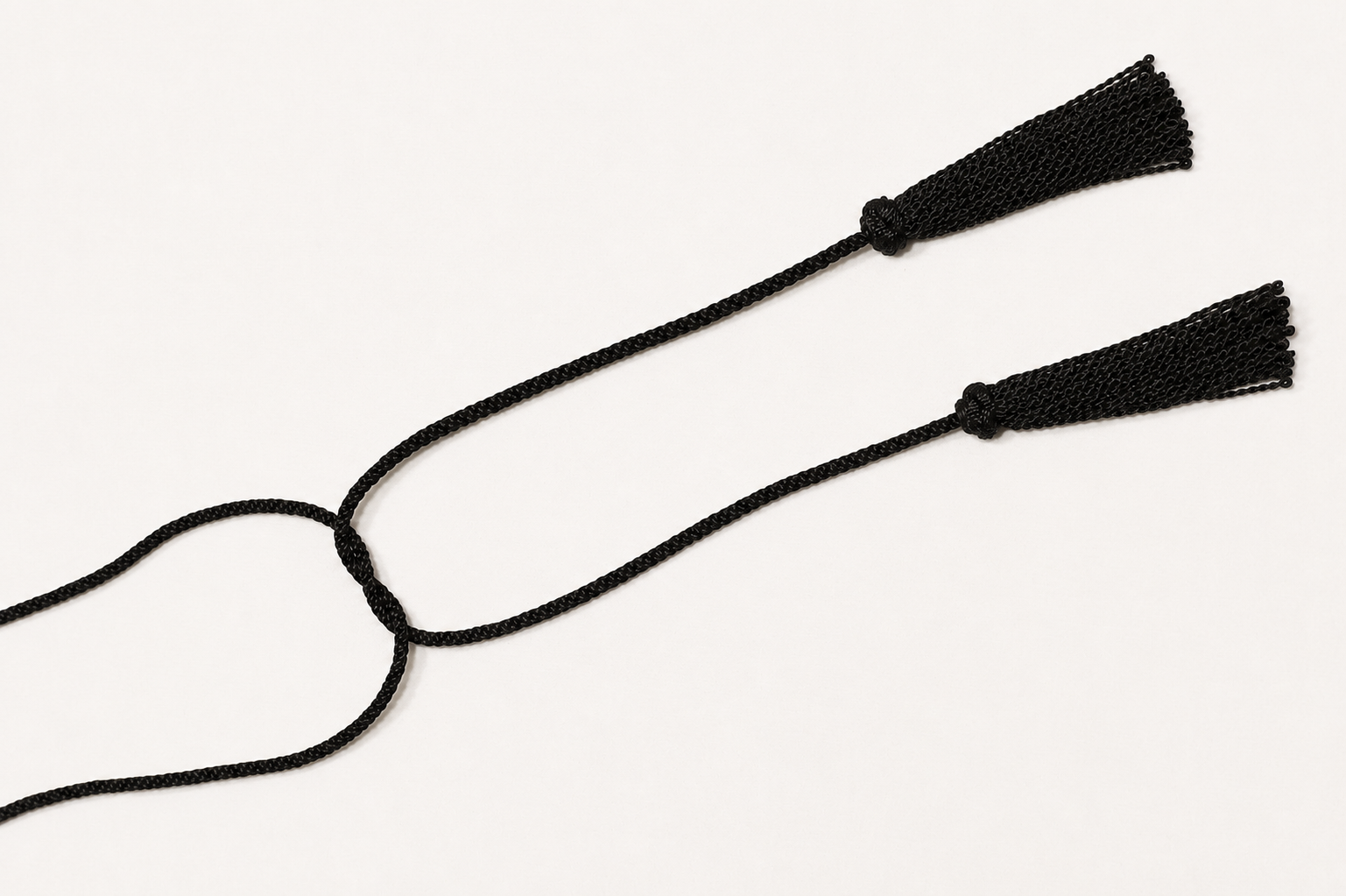 Black cord with two tassels on a white background
