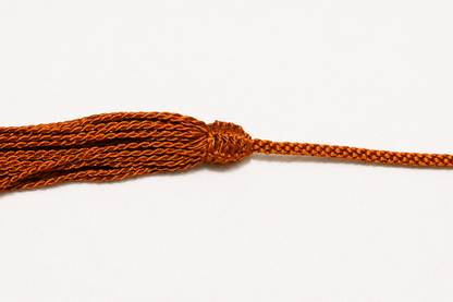 Close-up of an orange braided rope on a white background