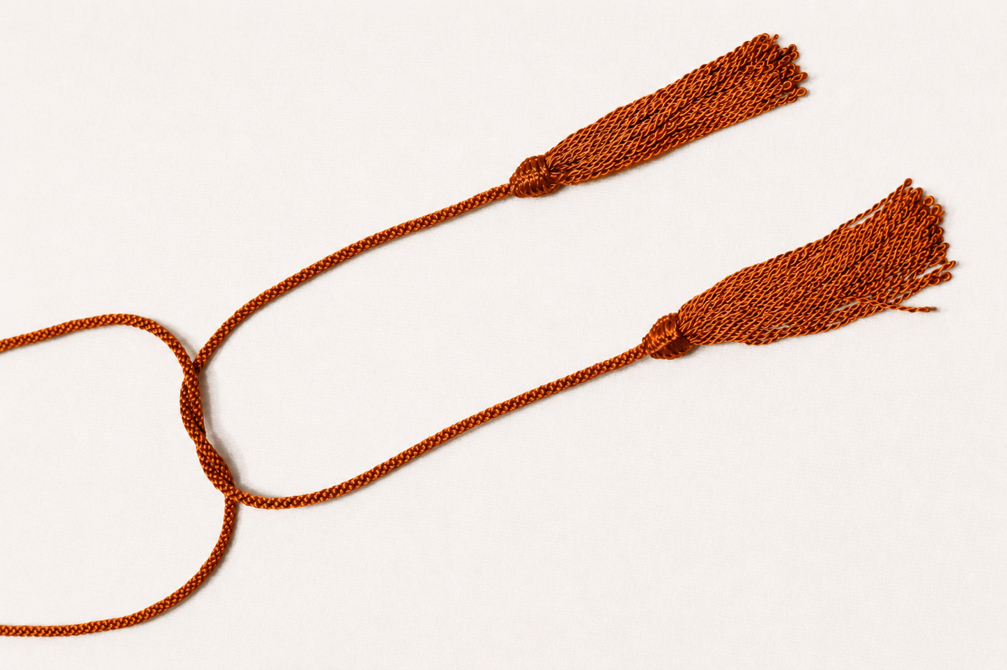 Two brown tassels on a white background