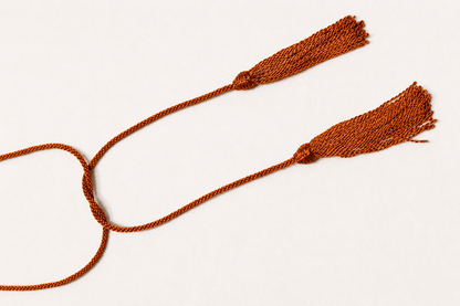 Two brown tassels on a white background