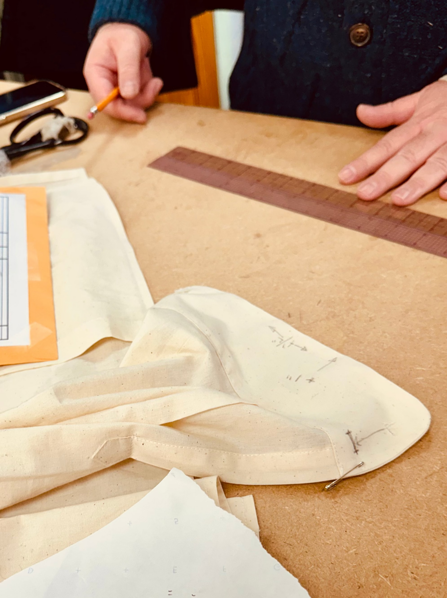 Person working with fabric and measurements on a table